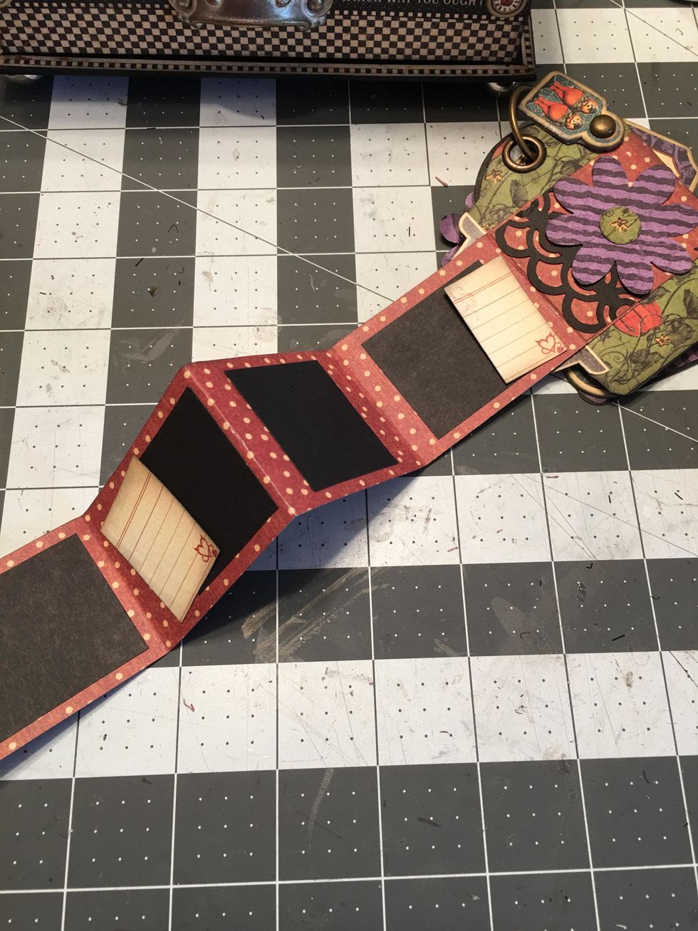 On the back side of your fold out, add small photo mats cut from black cardstock and little journaling boxes cut from the paper collection.