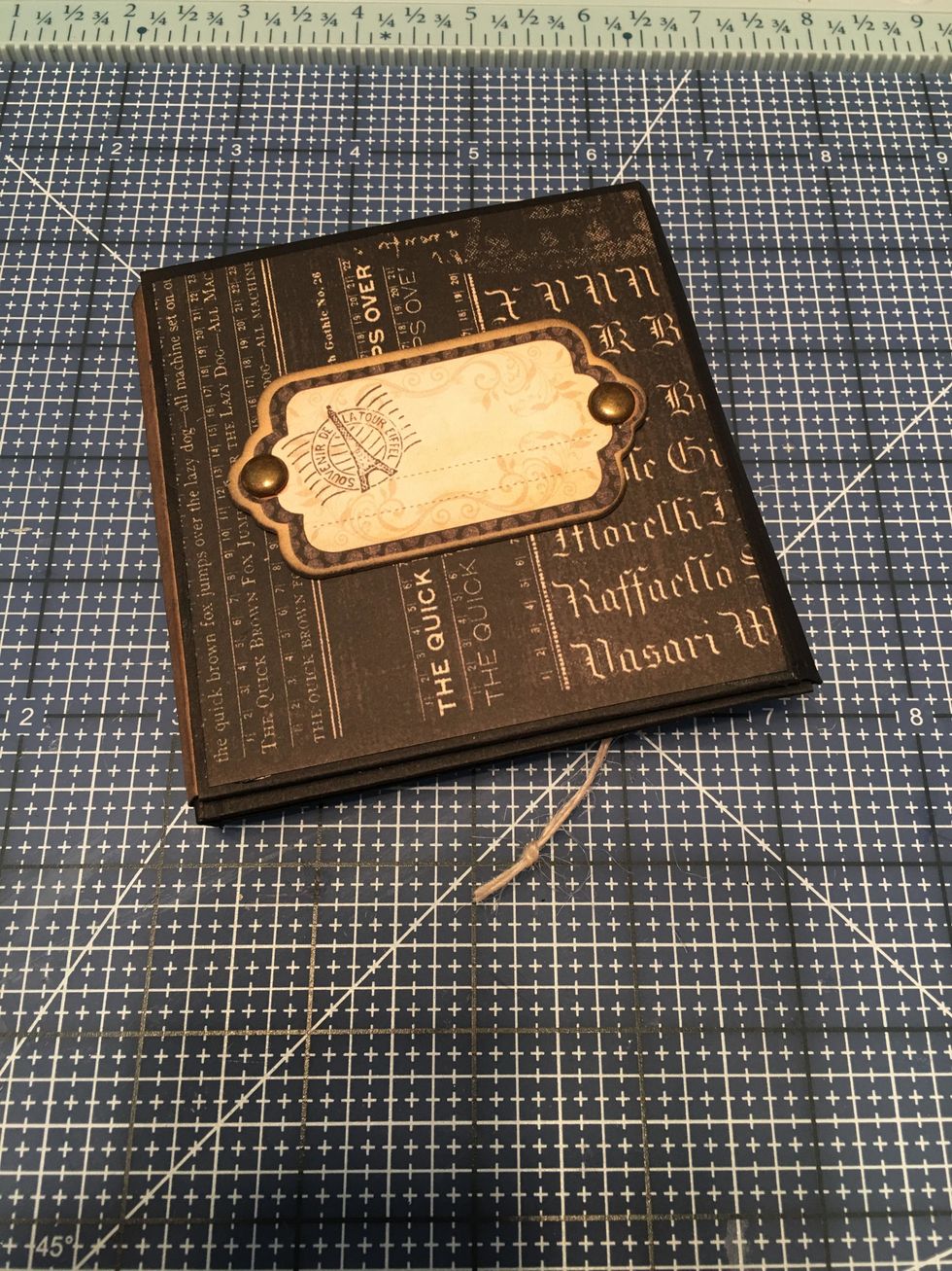 On the back you can add a chipboard element from the collection. Insert brads and cut off the prongs if they are too long for your piece. Glue to the back of your album.