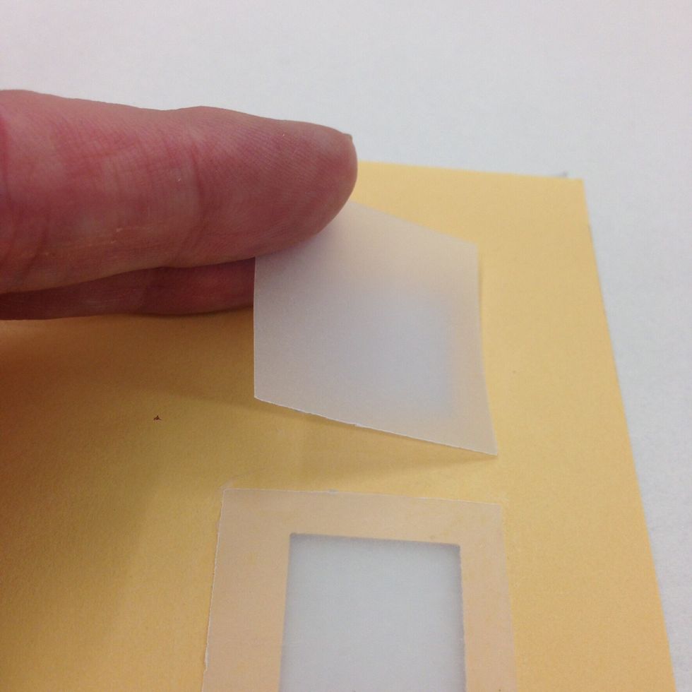 On the backside of the house, outline each window with the glue stick. Place a vellum square over each window and press in place.