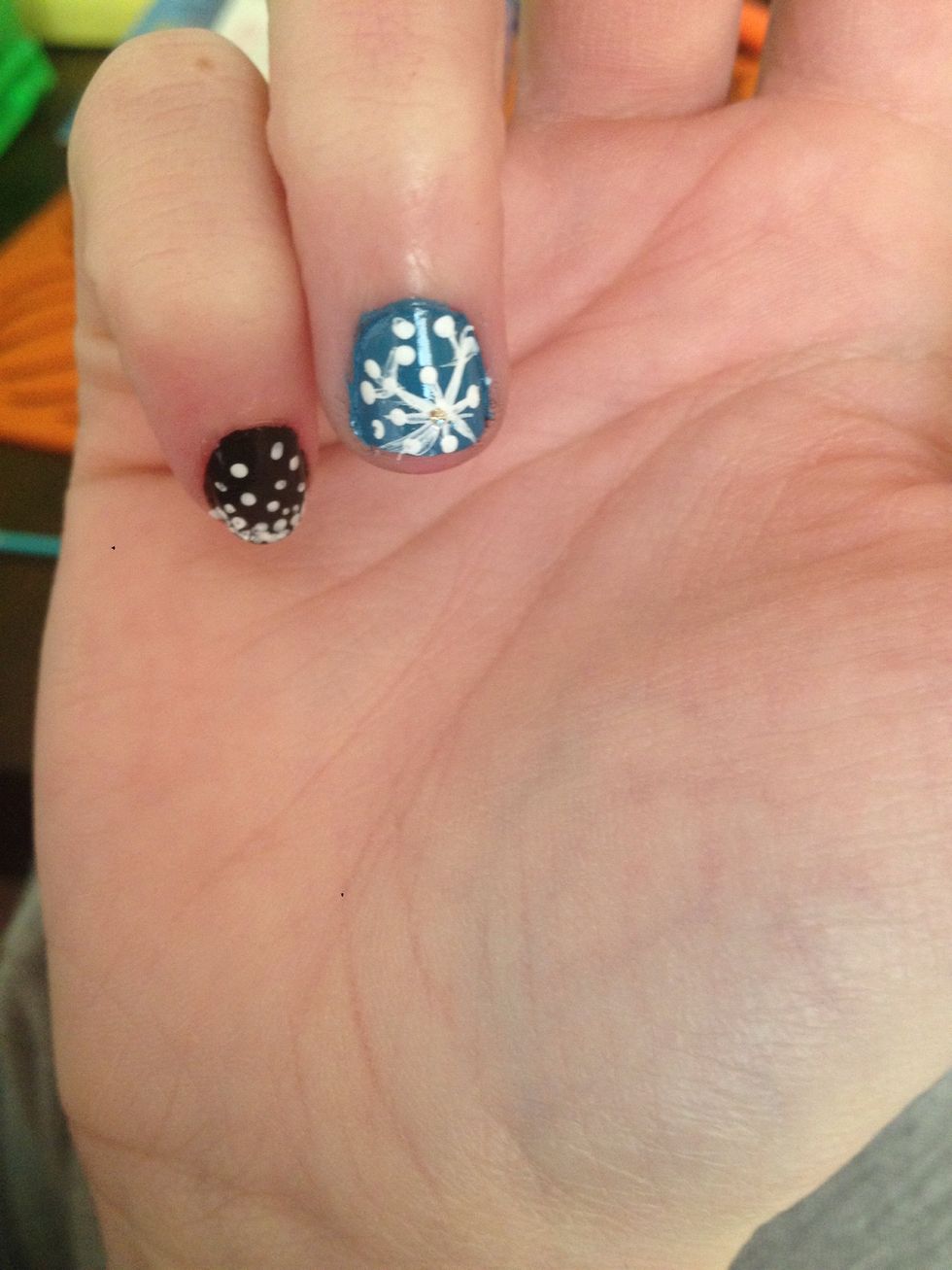 On the blue nails, take a nail art brush and draw a little snowflake or two!