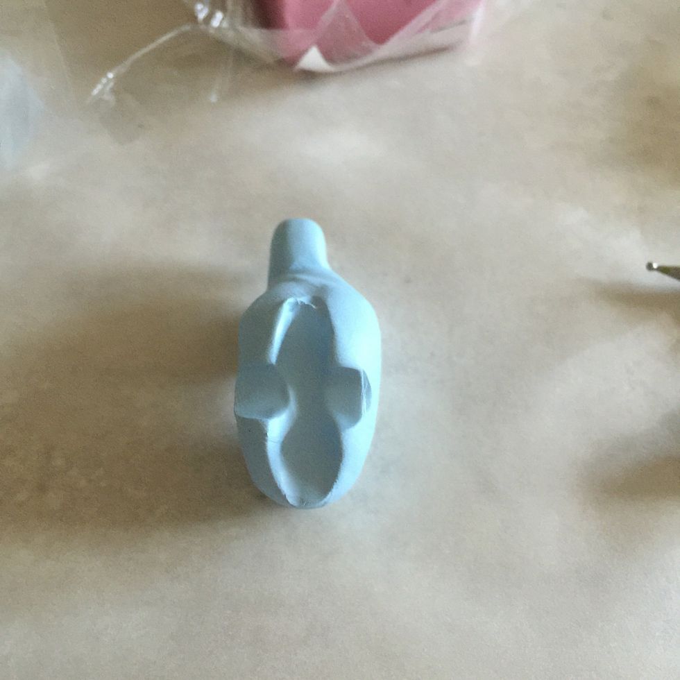 On the bottom of the animal, grab a pen or pen-like object and push into the animal both vertically and horizontally. The pieces sticking out will become its legs.