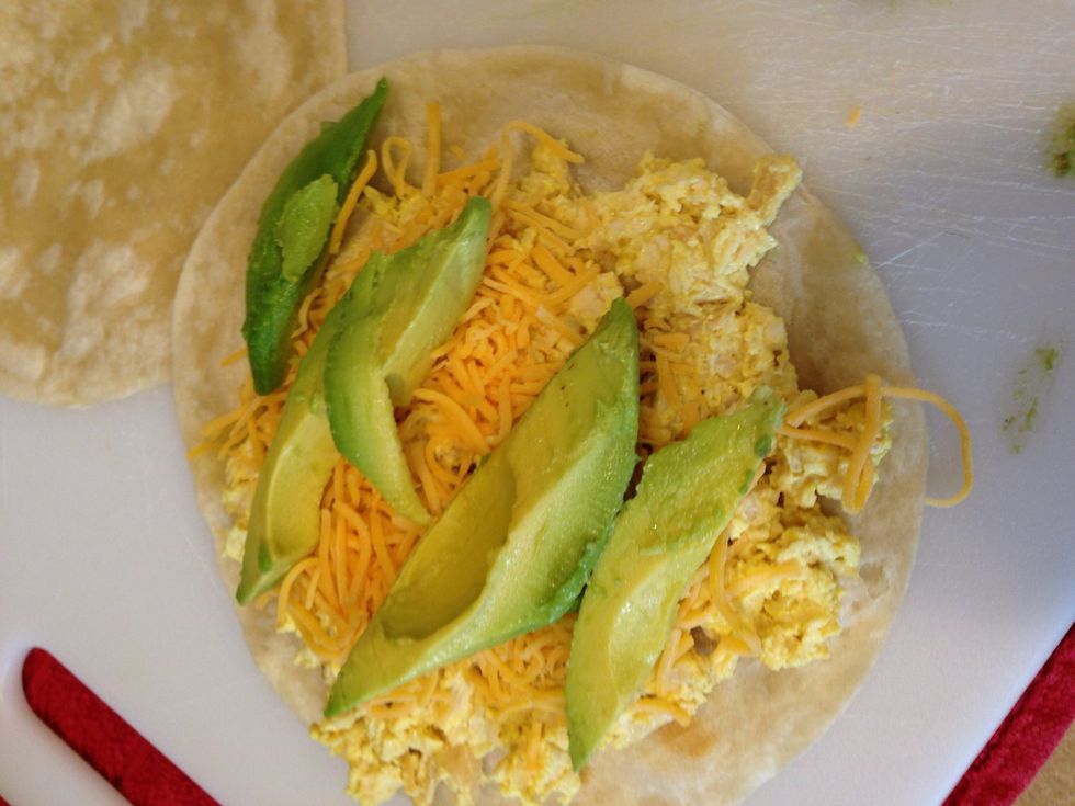 On the browned side of tortilla add the 1/4 C of cheese on top of the chicken, and add the avocado. Doesn't matter which order you put them on top.