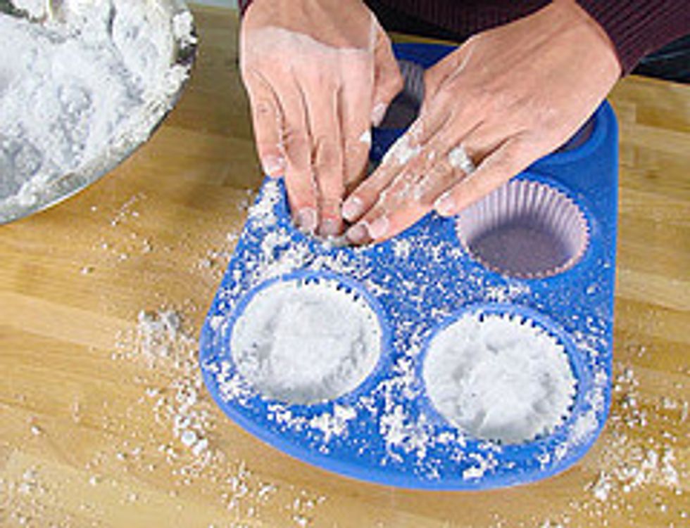 On the cupcake mold.Take a handful of the mixture and press firmly into the molds. The more dense and packed the fizzes are, the longer they will last in the tub.