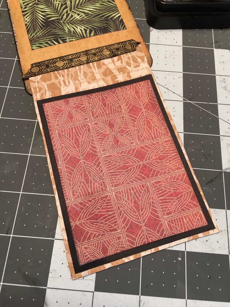 On the flap side, measure and cut black card stock to mat over the magnet. Also measure and cut patterned paper to layer over the black cardstock as shown.