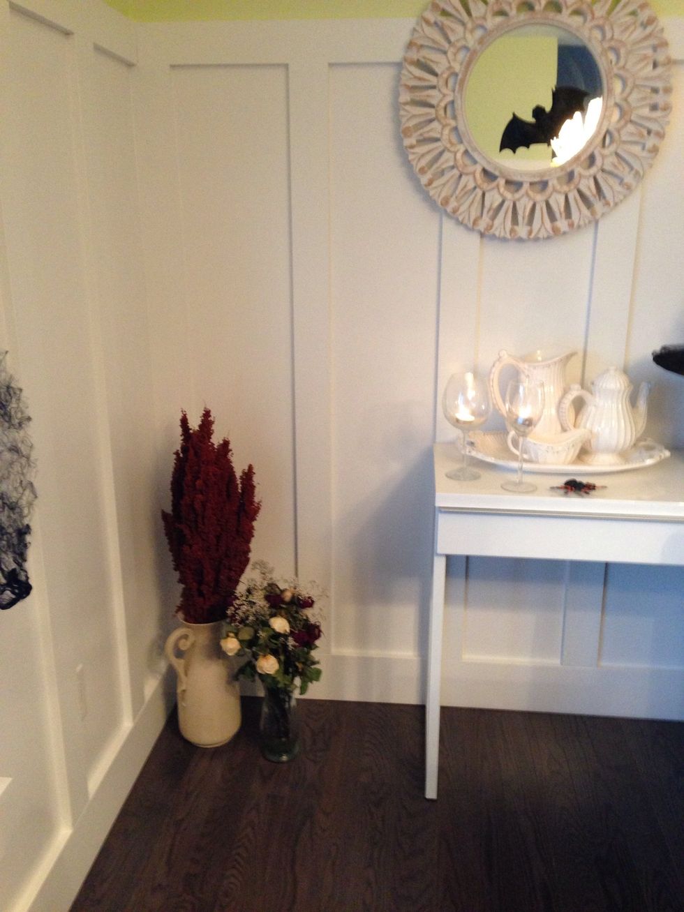 On the floor, fill 2 vases with dried flowers or branches. Ideally, they should have different heights. Also scatter as many wine glasses containing votives around the room, to your liking.