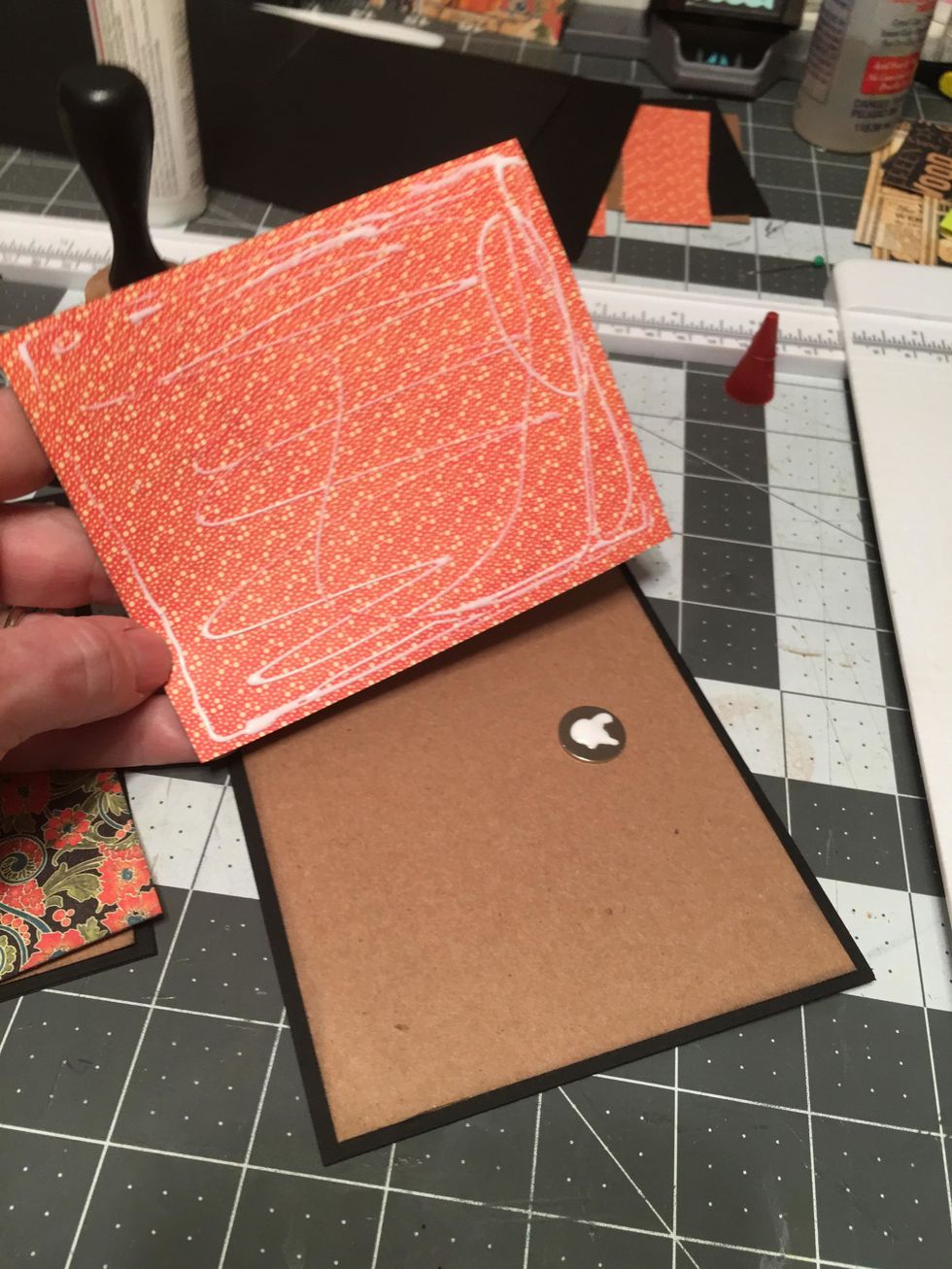 On the kraft side of one of the covers, attach one magnet to the right side, centered and about 3/4" from the edge. Apply glue to the patterned paper for the cover and to the magnet.