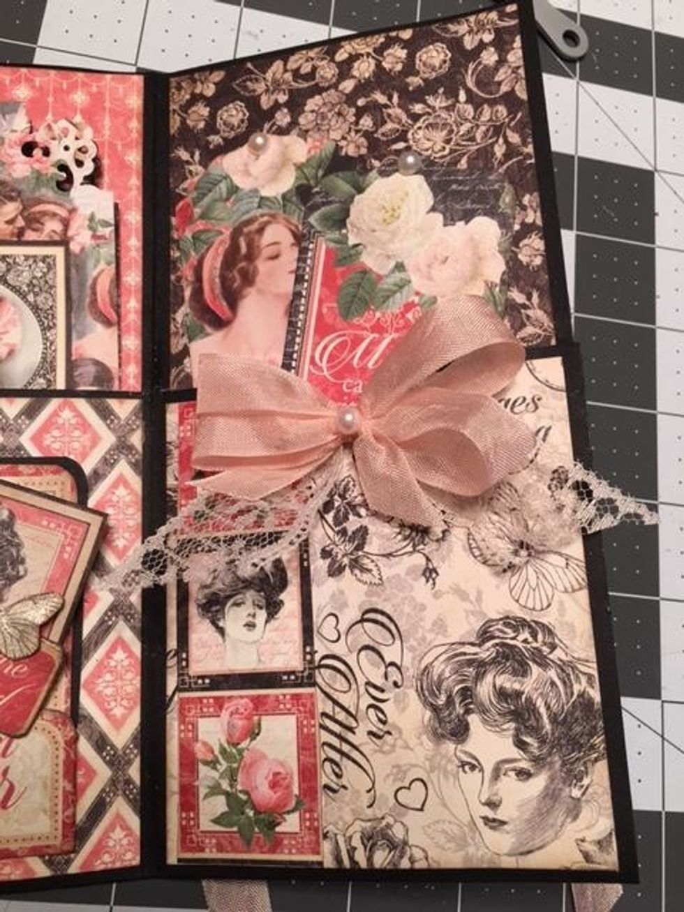 On the last pocket section,tie a bow with pink seam binding ribbon, add a pearl to the center&glue the bow and some lace to the top of the pocket. Glue a row of 3 "stamps" from the 8x8paper. Add tags.