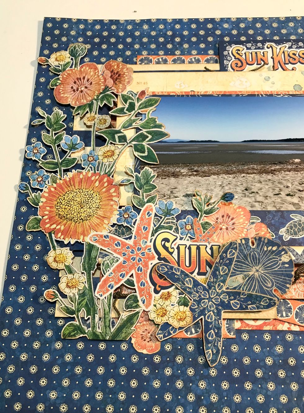 On the left hand side of the photo, adhere the flower bunch, 2- 2 pink flower bunch, 1 starfish & one sand dollar.