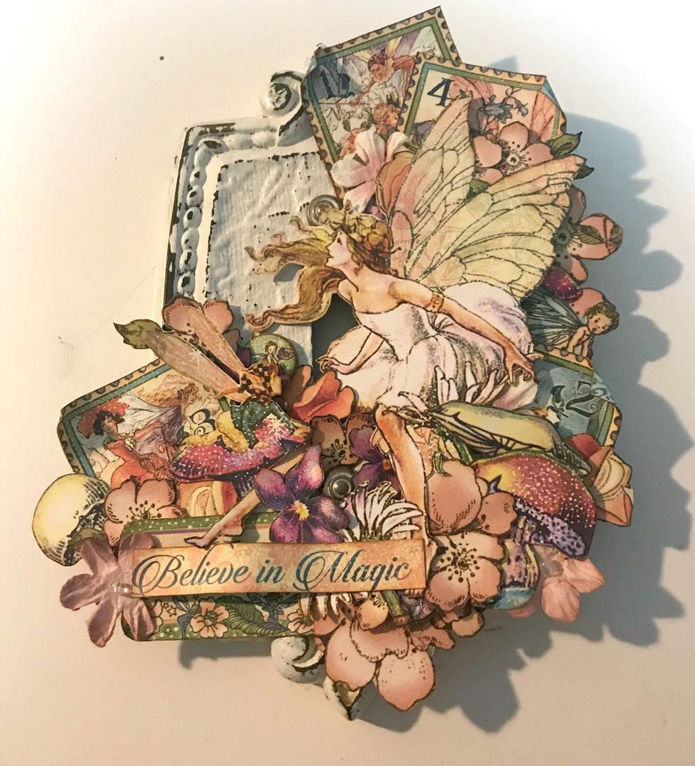 On the left side above the stamp, adhere 1 small pink flower, 1 coral flower and 1 chipboard circle.