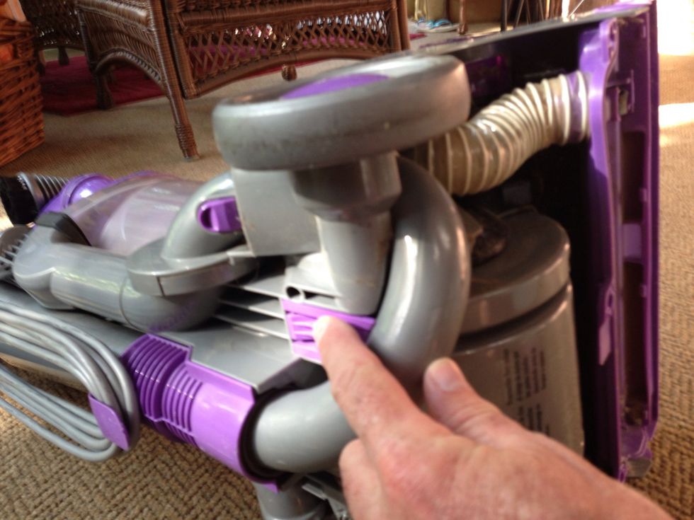 On the left you'll see a U shaped plastic piece. Slide it out using the purple button