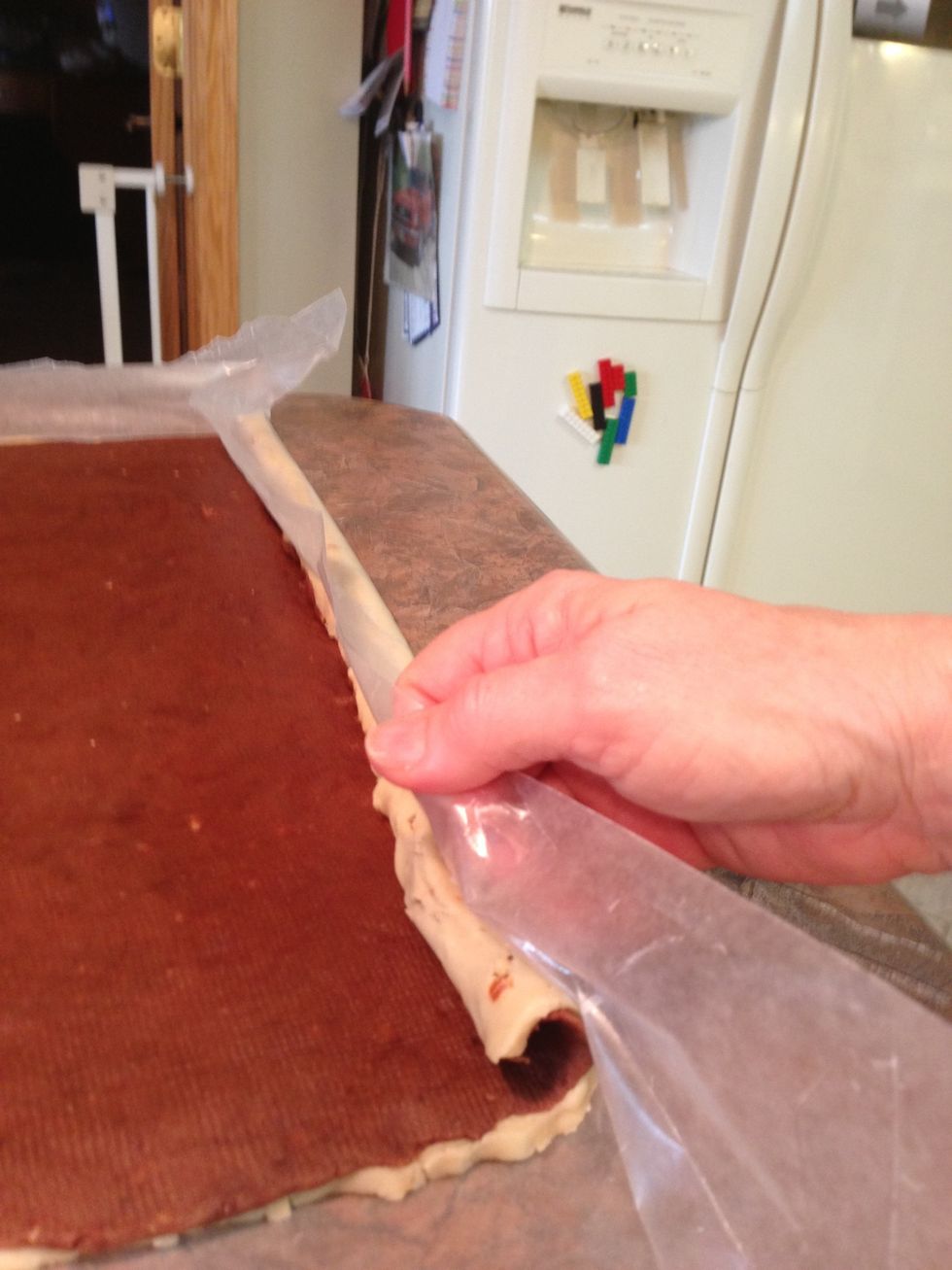 On the LONG side, using the bottom wax paper to help you, roll up slowly and tightly into a cylinder, being careful to not allow spaces between layers.