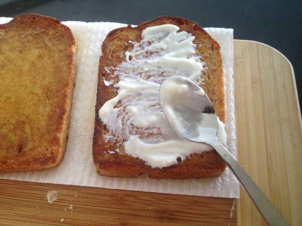On the other slice of bread, spread a small amount of garlic sauce.