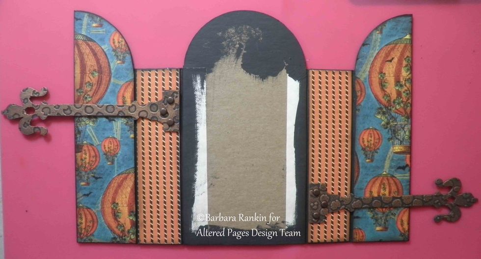 On the outside, attach hardware hinge die cuts with brads to the book spines, as shown.