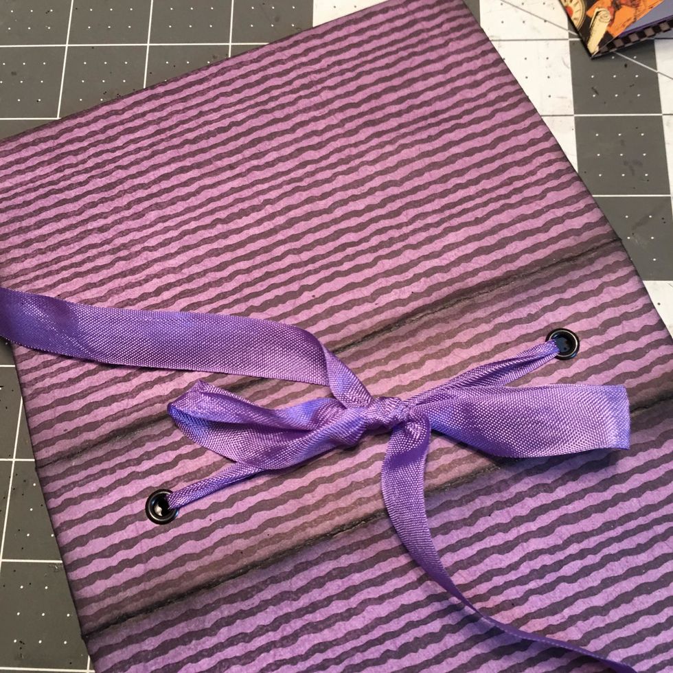 On the outside, tie a loose bow for each ribbon of a signature set.  Tie it so you can untie it later to tighten the pages.