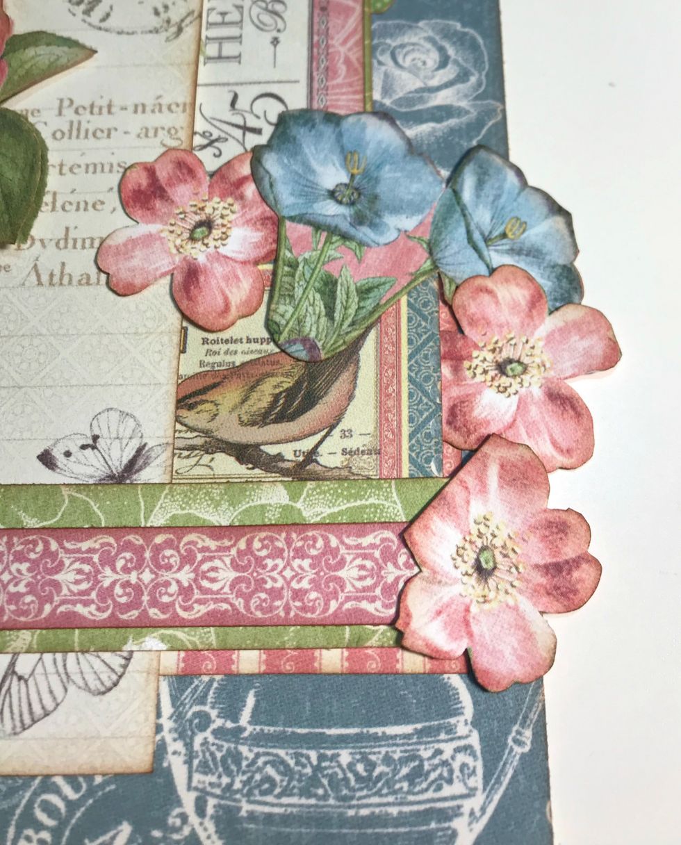 On the right side of the border, adhere a blue flower bunch and three pink roses.