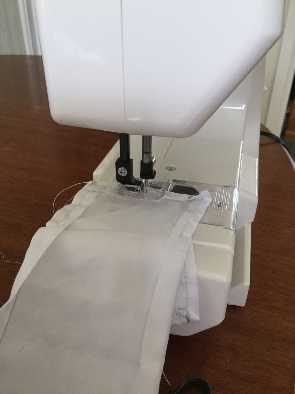 On the sewing machine, sew the tacked edges of the material separately. Do this on both pieces of material.