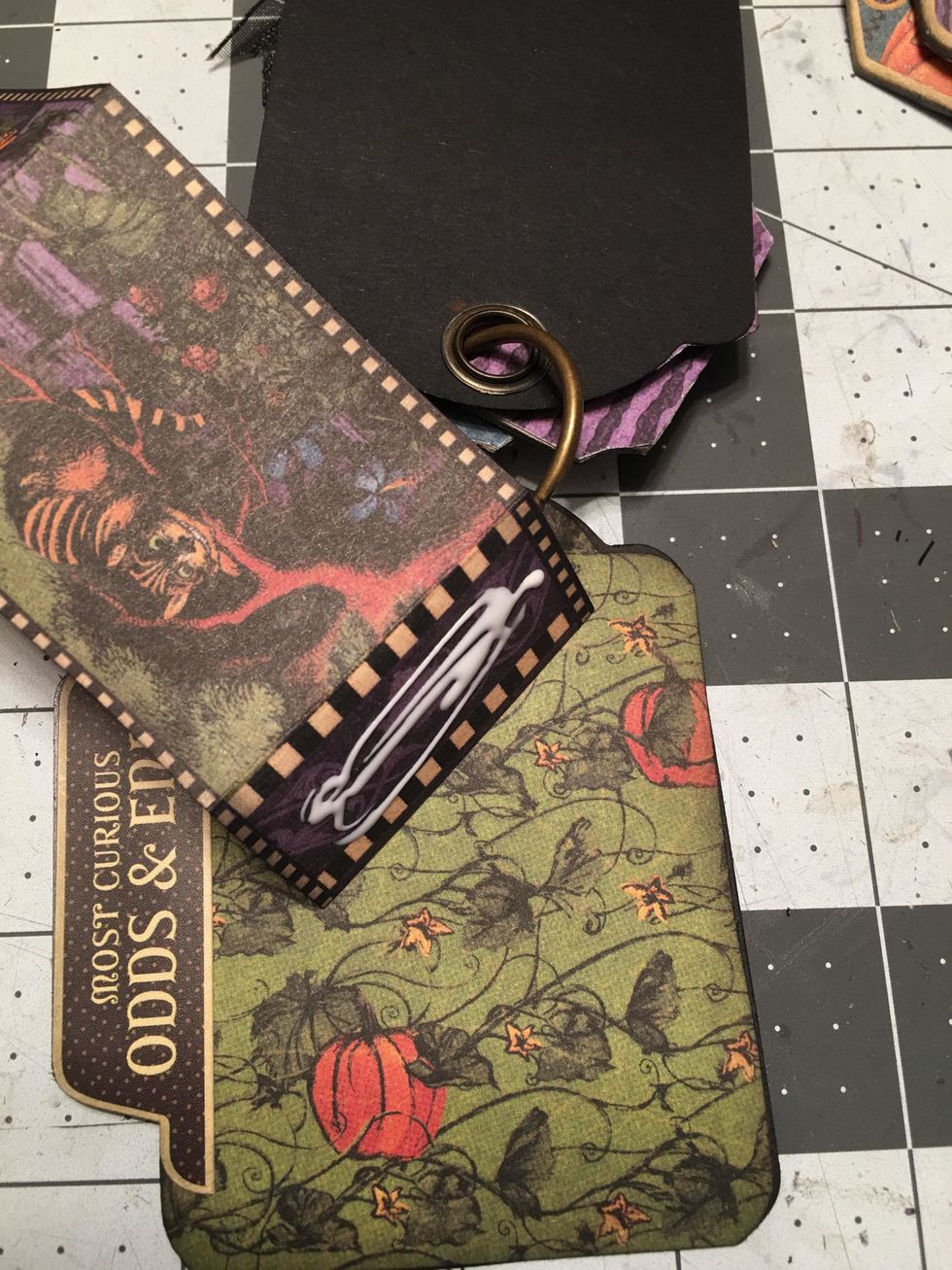 On the shortest edge piece, apply glue to the flap and glue that to one of your tag "pages."