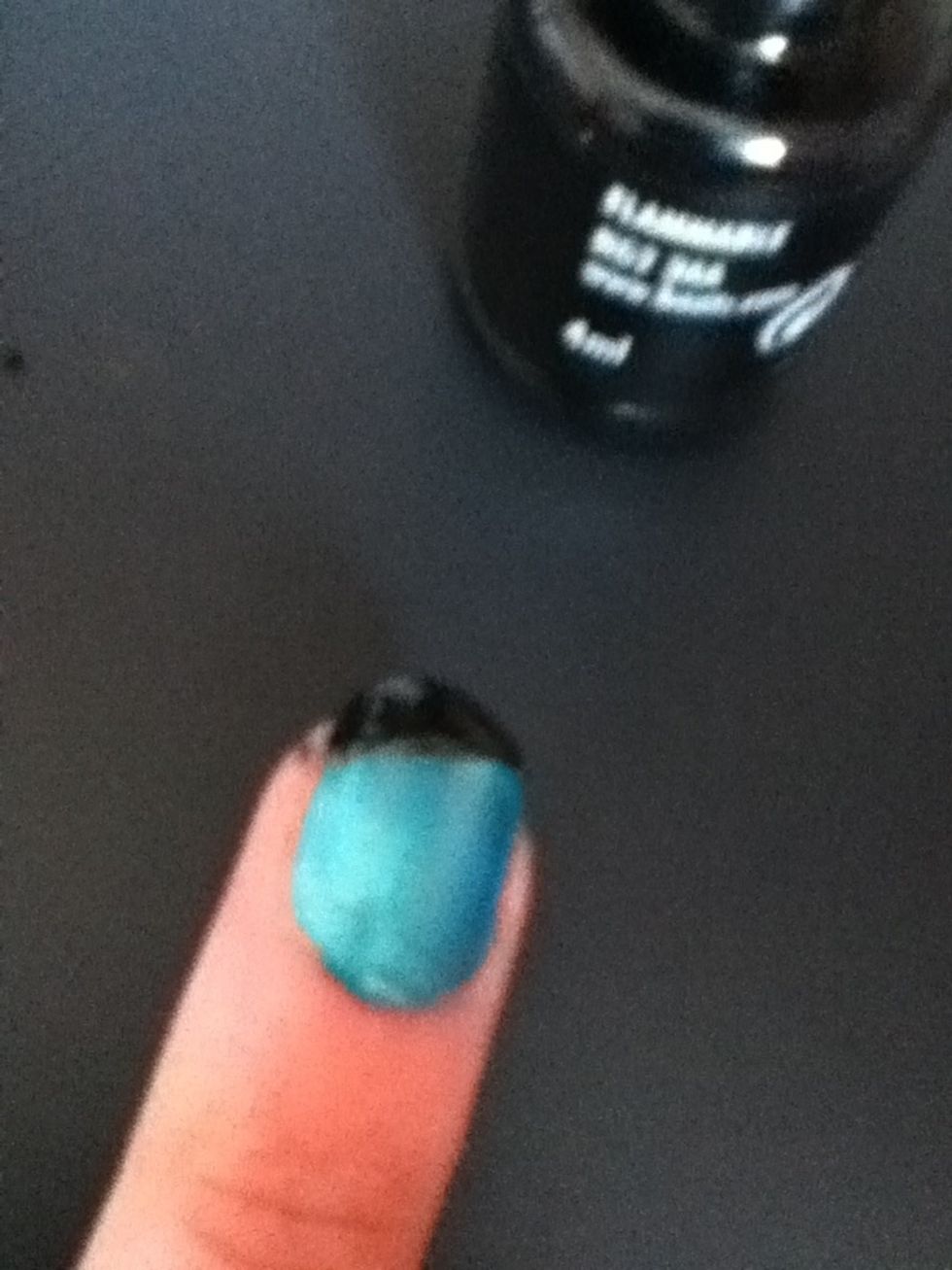On the tip of the nail, paint a slanted line with a black nail polish.
