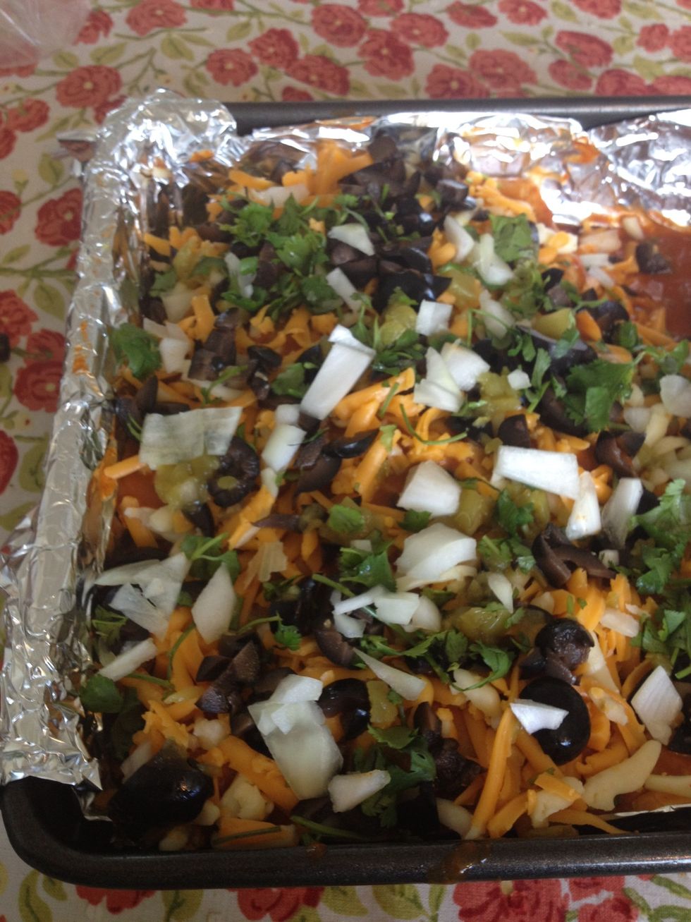 On the top, also put cheese as well as any other left over ingredients - the black olives, cilantro, onions, or green chilies. It looks beautiful and delicious, \u00bfverdad?