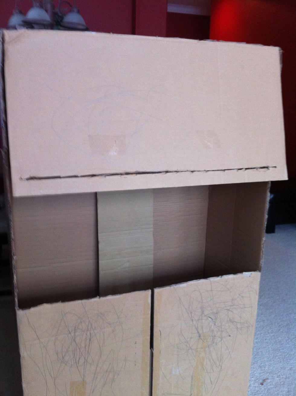 On the top flap, cut a line through, this will be the part for the curtains. Make it wide enough for movement. I put tape on the bottom opening so the curtains glide a bit more.