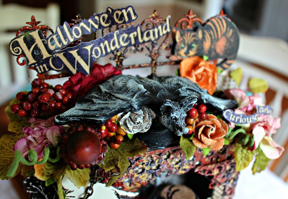 On the top of hall tree add embossed gate and a resin bat that has been dry brushed with Titan Buff paint. Add flowers, berries, etc randomly around the top of hall tree.