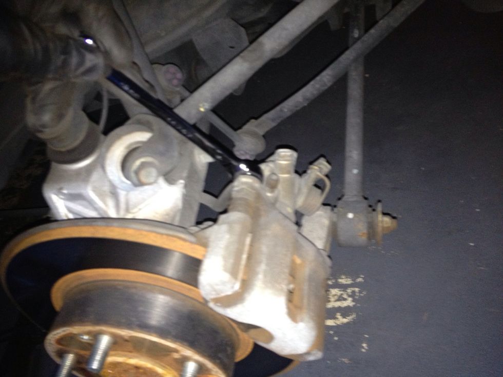 On the top of the caliper, use a 12mm wrench to remove the top