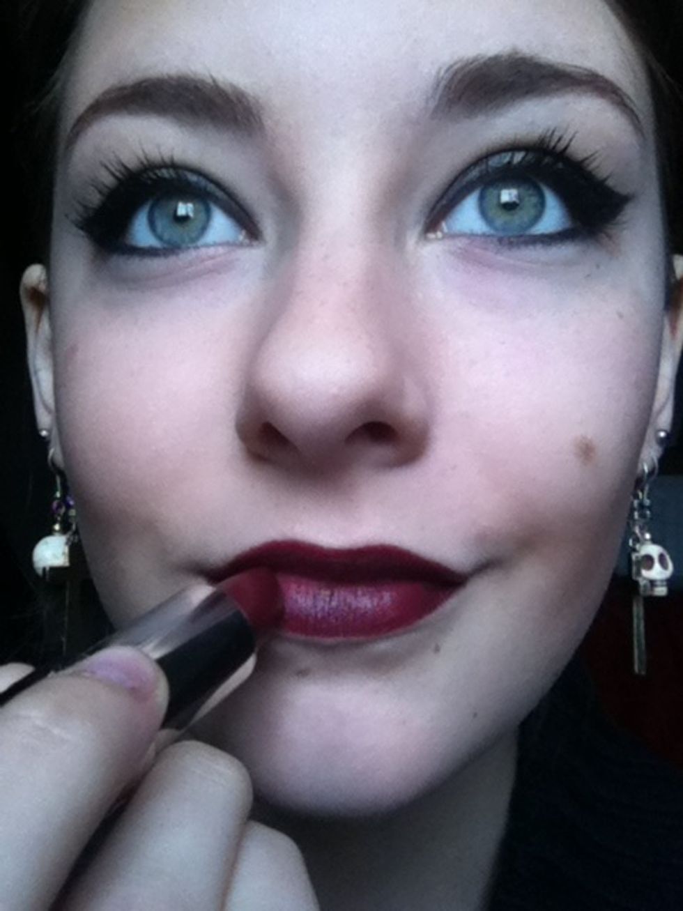 On to lips, apply a cranberry lipstick.