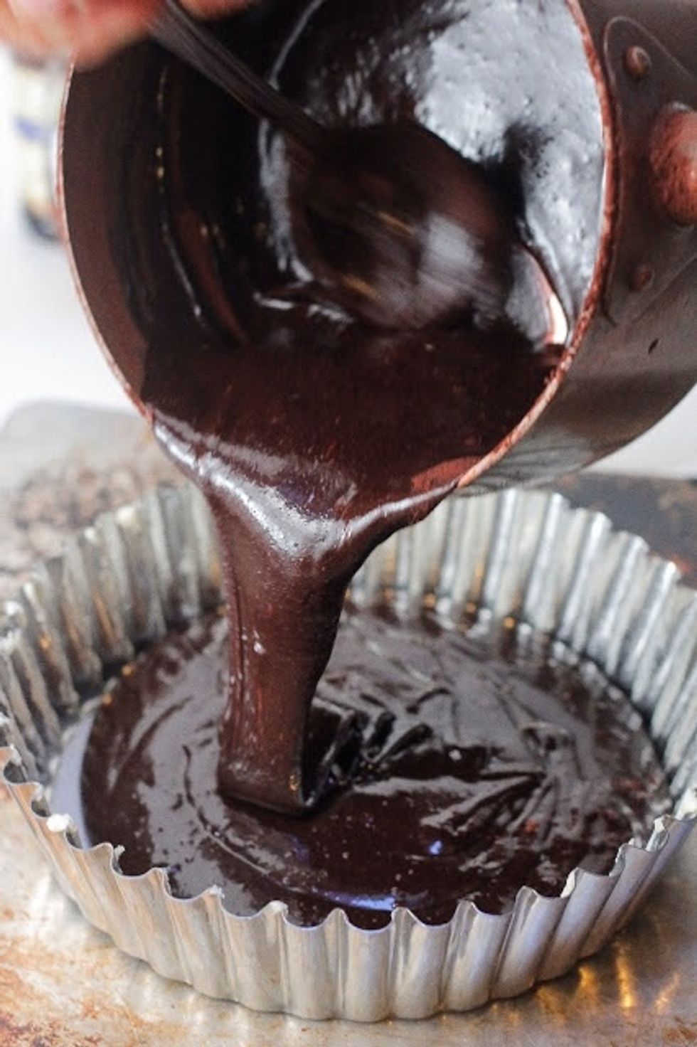 Once again, mix everything together well. Pour the cake batter into the greased tart pan. Set the pan on a cookie sheet , slide it into the oven. Bake the cake for about 25 minutes or until it's firm