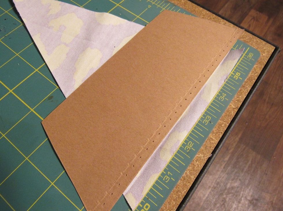 Once all flags are cut, measure about an inch and a half to fold over to thread the baker\u2019s twine through. Repeat this for each pennant flag.