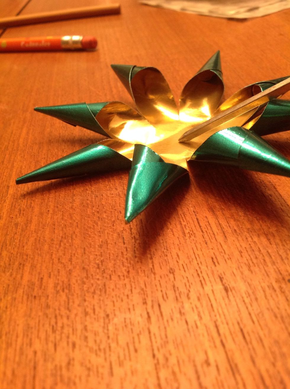 Once all of the stars have points, poke a small hole in the middle to thread the stars together.