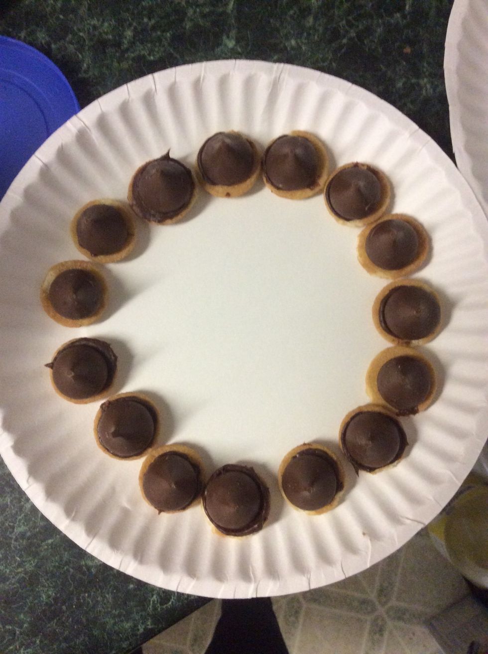 Once all the chocolate is added to the flat side of the cookie you can add the Hershey kisses
