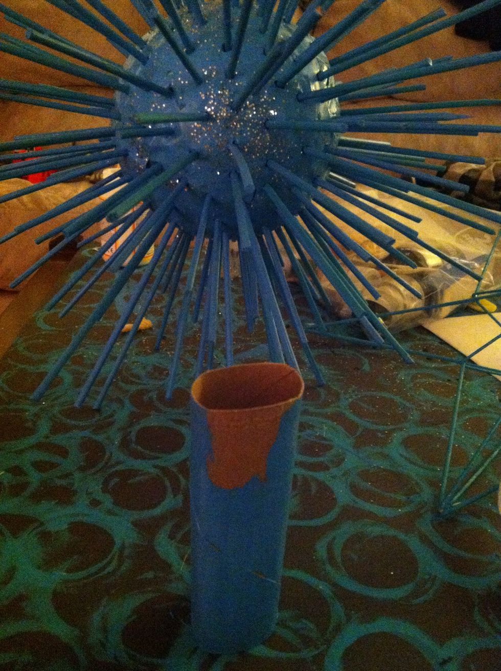 Once all the sticks and styrofoam are dry, paint a toilet paper roll and push it carefully into the styrofoam.