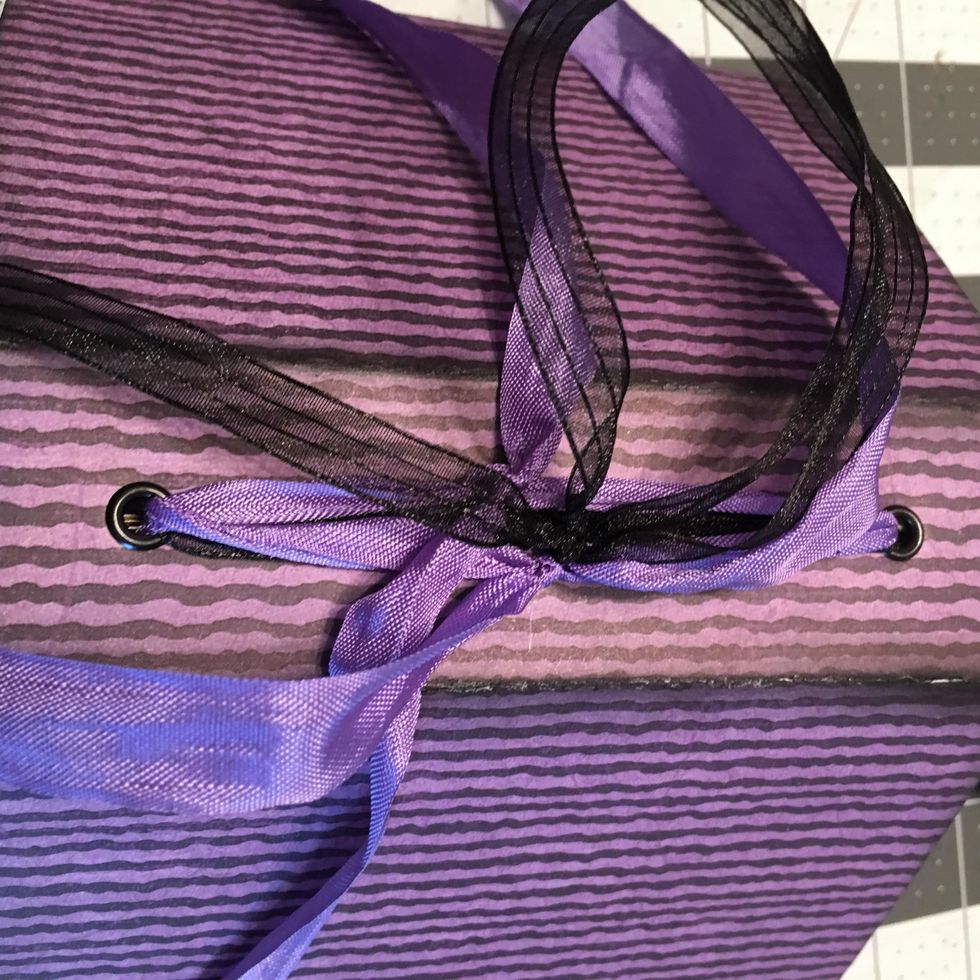 Once all three signatures are in the book, untie the bows and pull gently but tightly and tie in a very tight knot.