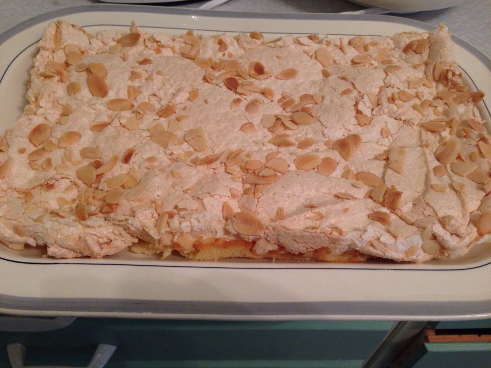 Once cool, use a flat spatula to separate the cake from the parchment paper. Cut the cake in half and place one of the pieces onto a tray (this is half of the cake).