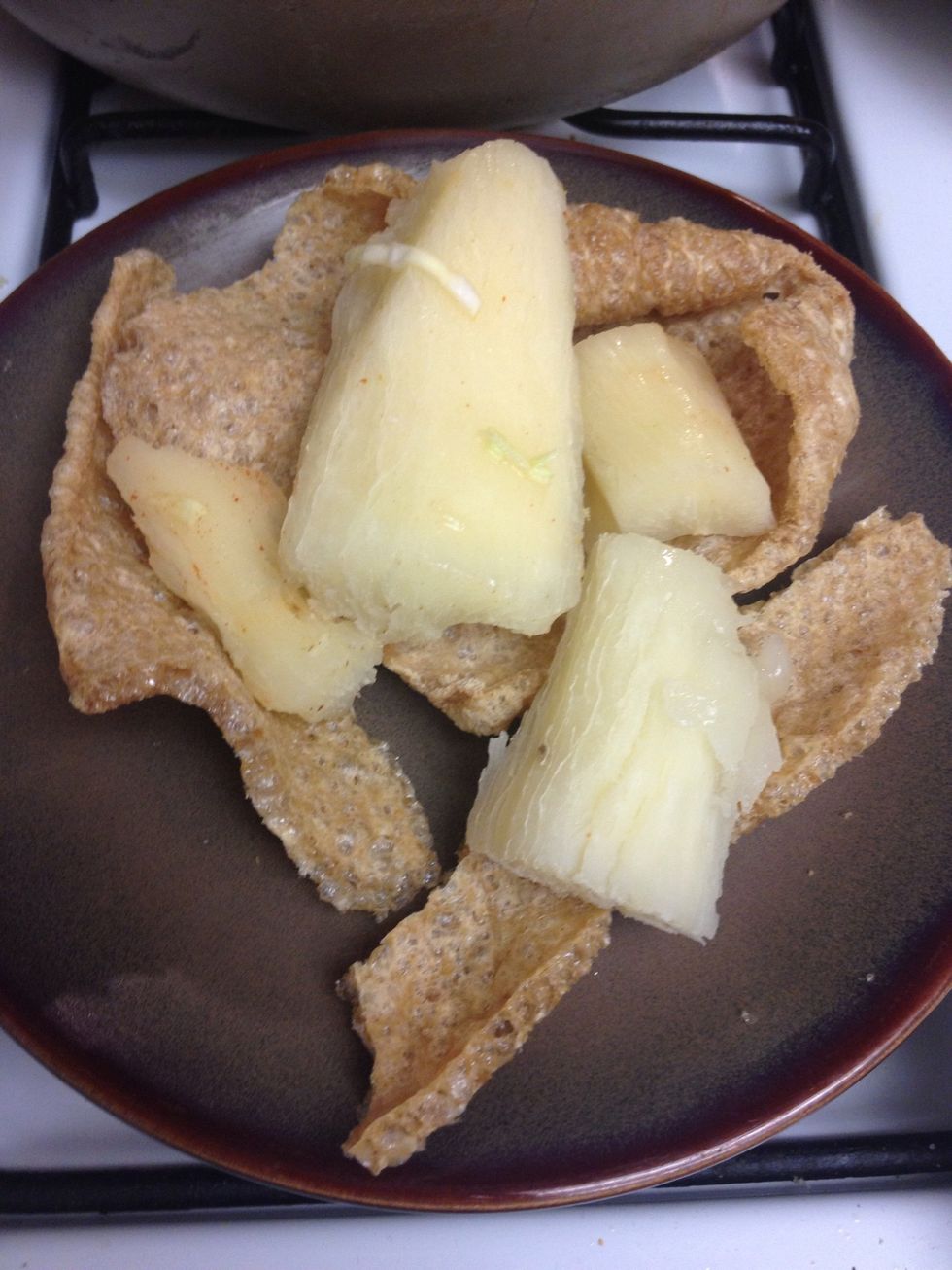 Once cooled, place the yucca over the chicharron (pork rinds)