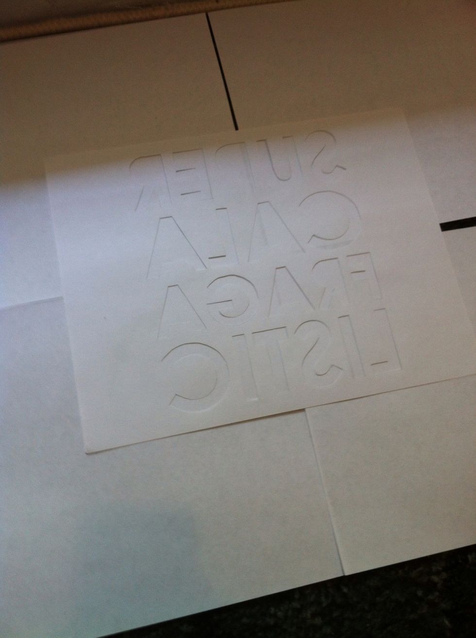 Once done creating your stencil, time to put it on the shirt. You will spray the back side of the stencil with the spray adhesive. *my adhesive gets kind of sticky, so I placed it on top of something*