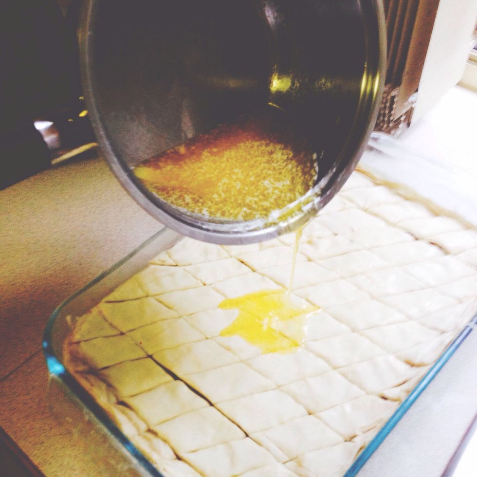 Once done cutting, evenly pour the remaining melted butter over the top of the cut baklava. You can always melt more butter if you ran out, or skip this step if you are terrified by all the butter!