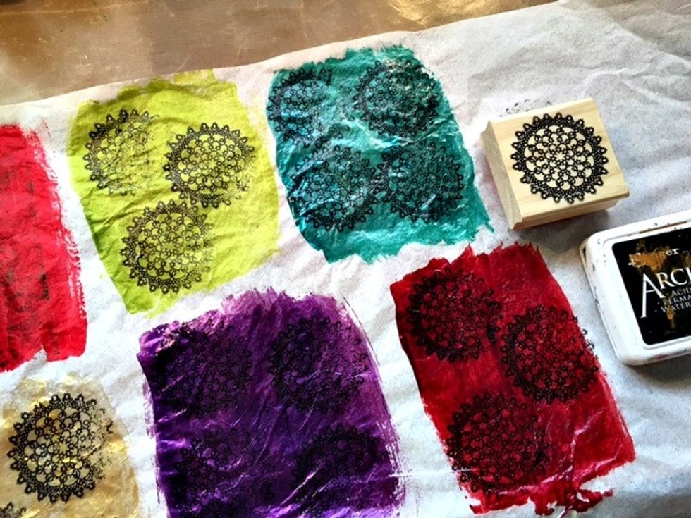 Once dry, take your stamp of choice and using black archival ink stamp your image all over your colors. Heat set.