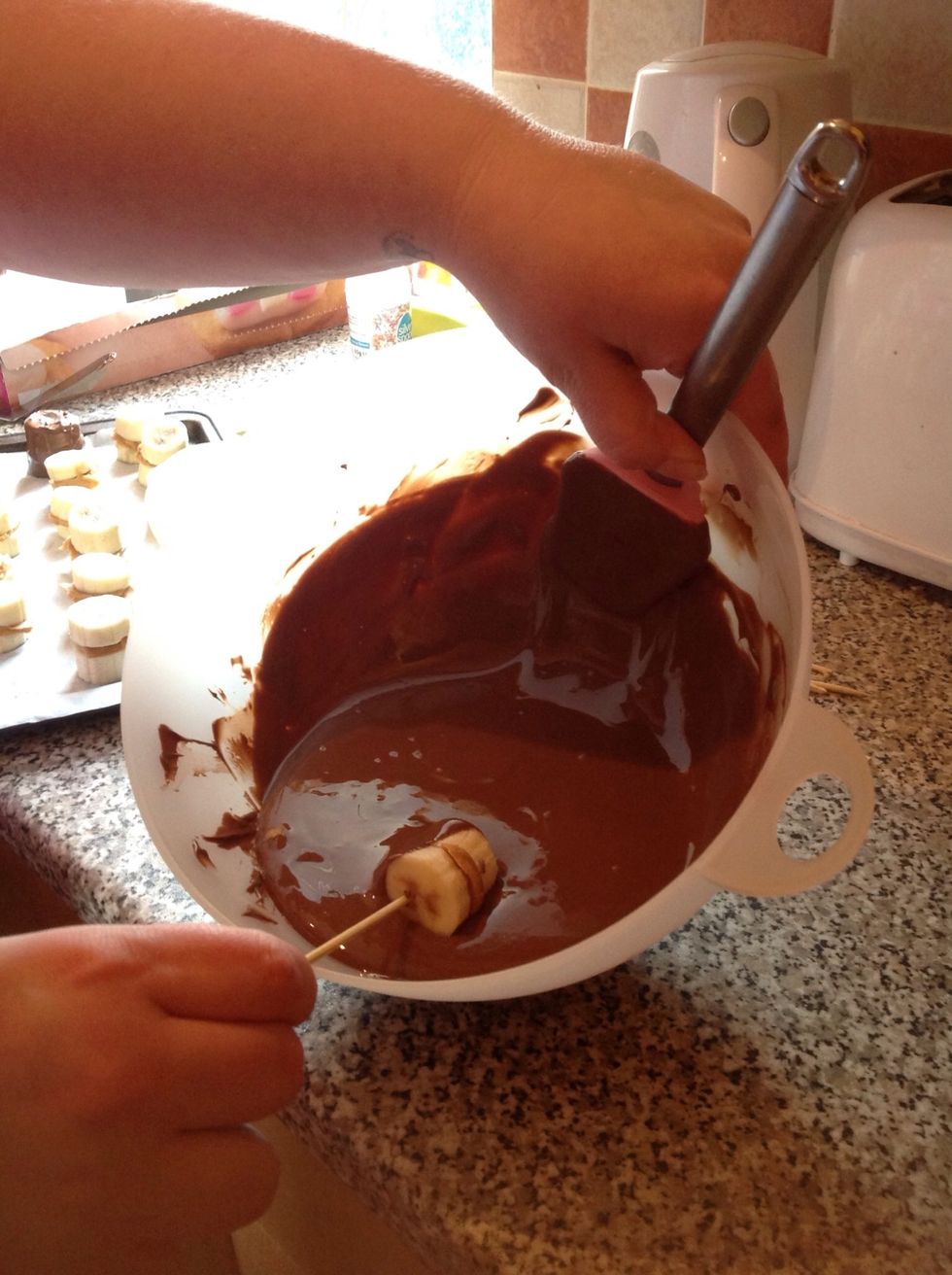 Once frozen, melt the chocolate and use a skewer to completely coat the banana piece in chocolate. Then put back in the freezer for about half an hour.