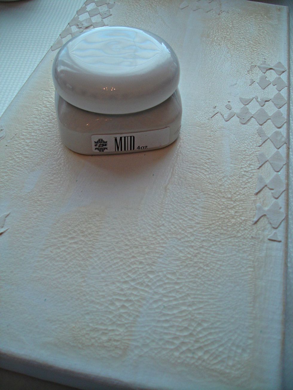 Once Gesso dried, I spread Clear Crackle randomly on the canvas. Then I used Art Anthology's Mud in a few places using a stencil.