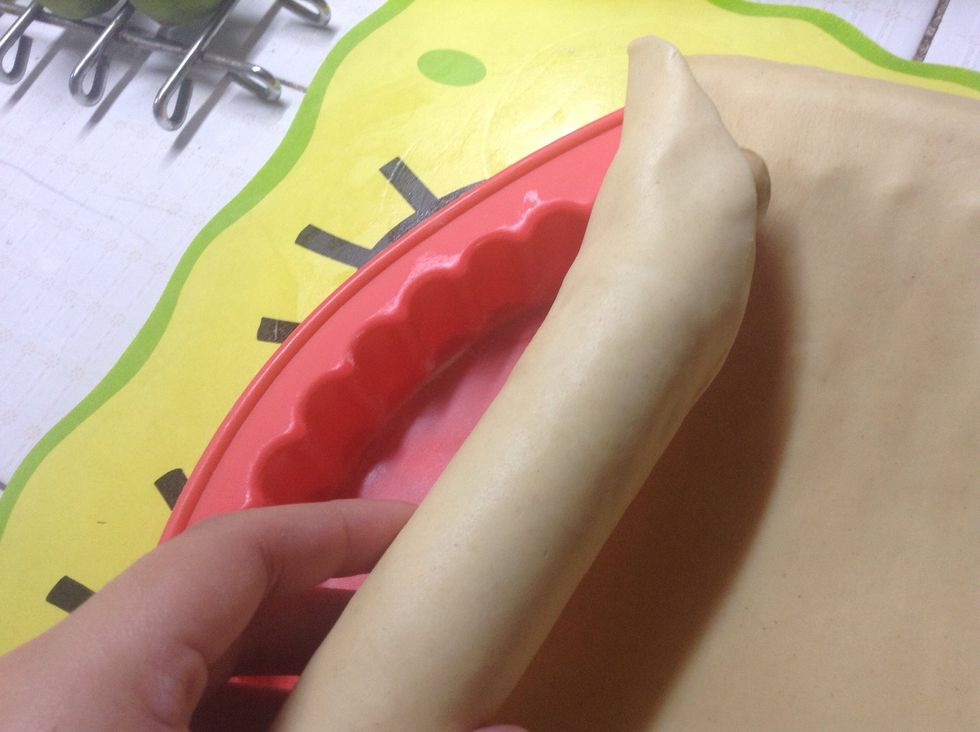 Once it is cold again, grab one side and place it in the roller pin and carefully start rolling it in. The idea is to take the dough from the mat to the mold without altering the shape it already has.