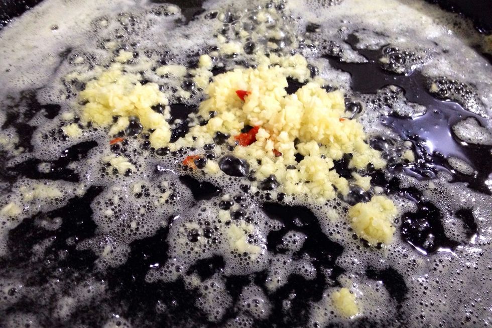 Once it melts, add garlic and saut\u00e9 until golden. Add drained cherry peppers and toss to combine. Turn heat down to low while you fry squid.
