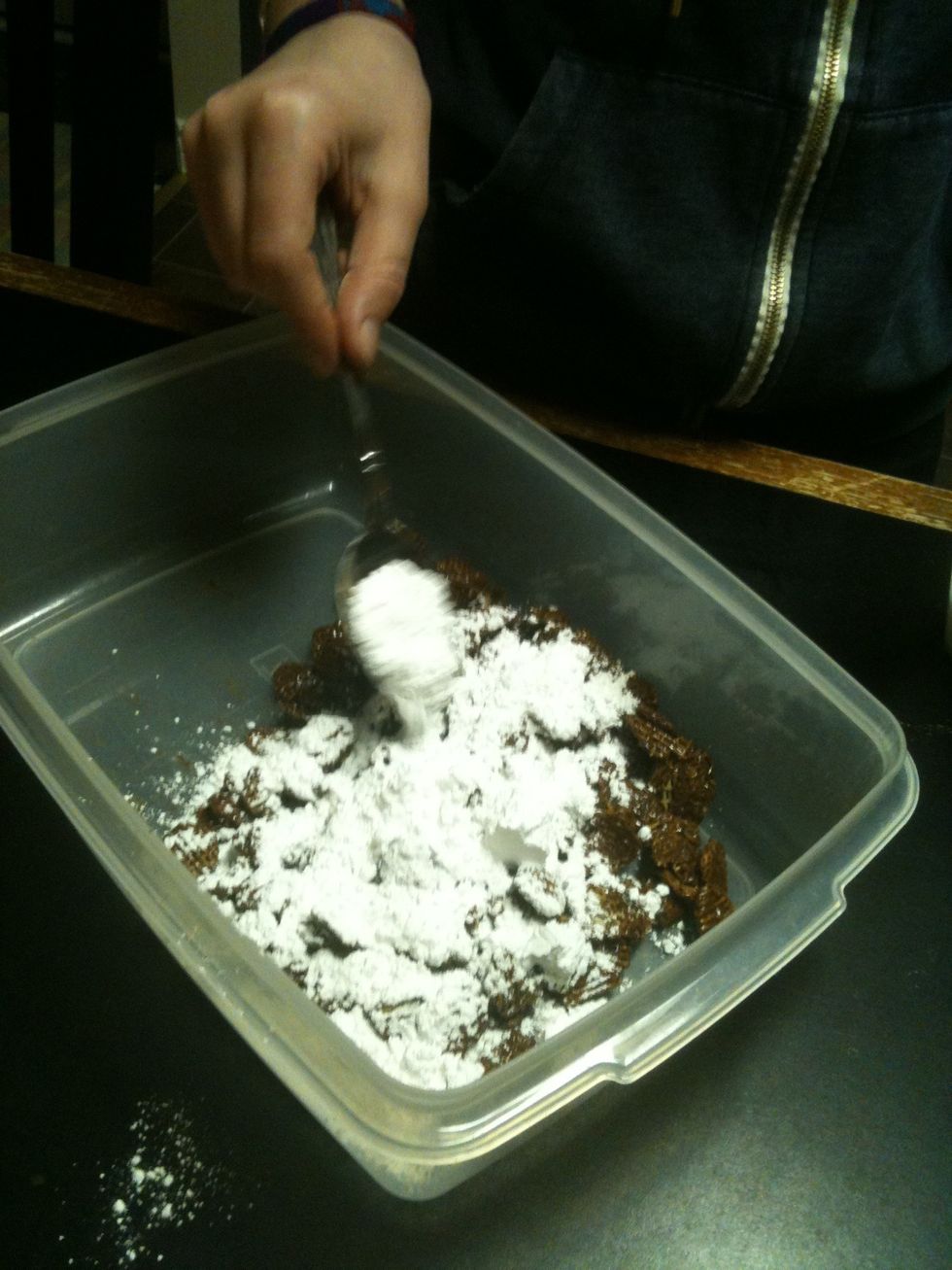 Once it's completely covered, scoop some into a container or plastic bag. Put afew spoon fulls of icing sugar into the container too. Close the container and shake  it untill the cereal is covered.