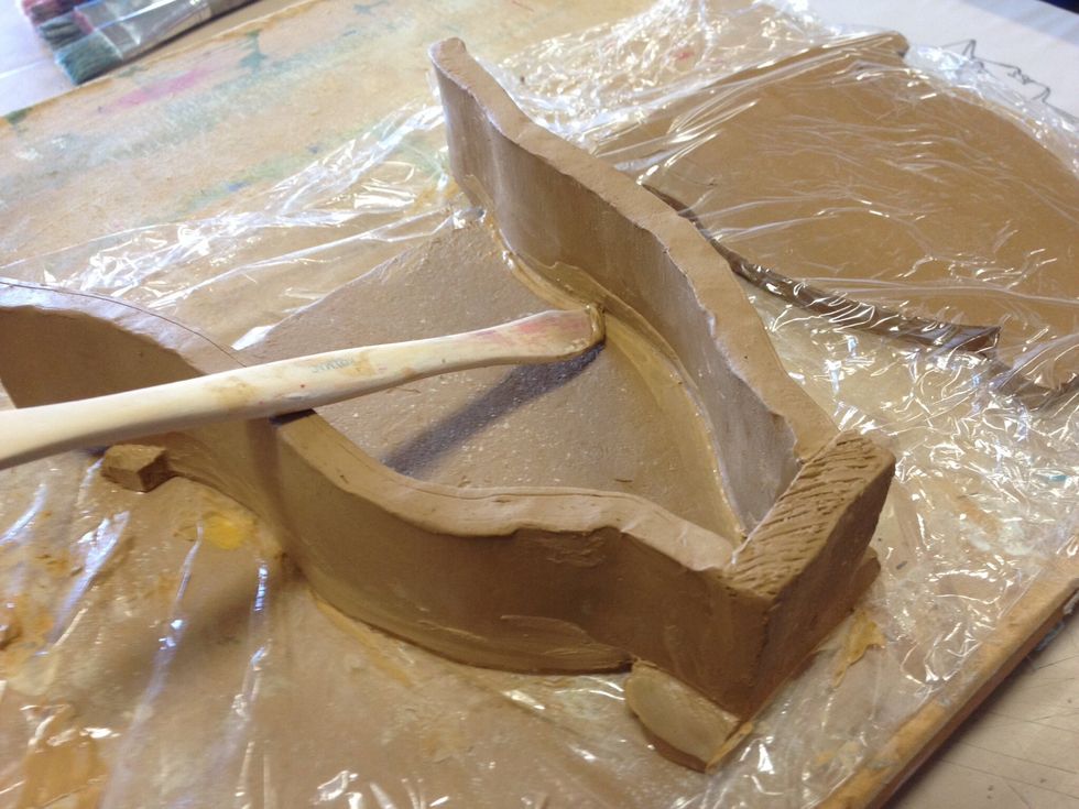 Once joined, use a clay tool to smooth the join and remove excess slurry.