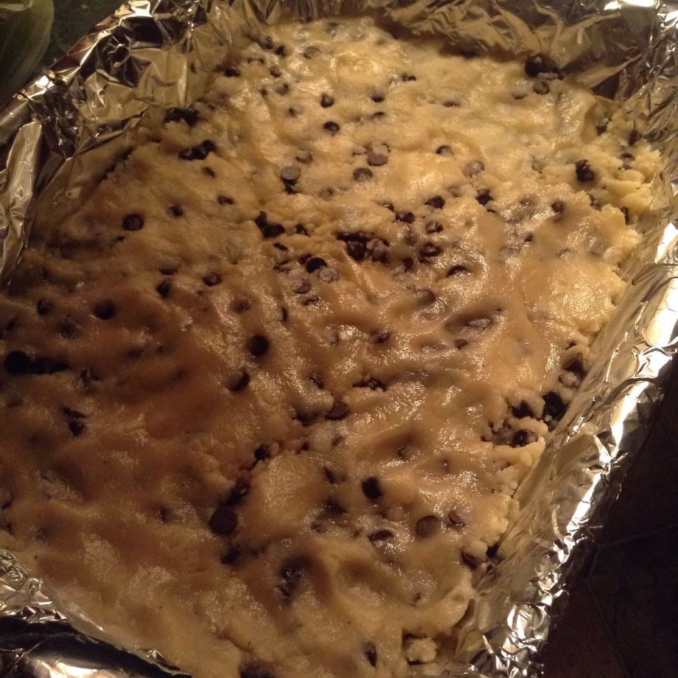 Once made, spread out cookie dough on an aluminum foil covered deep baking dish