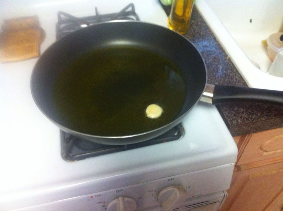 Once oil is heated, throw in a clove of garlic. (Don't forget to pull the garlic out once it has browned on both sides.)