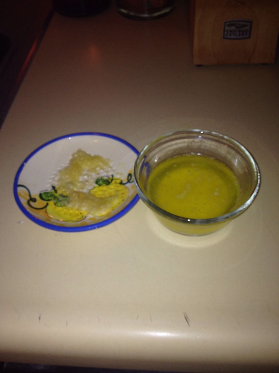 Once oven is preheated, spread pizza dough over a cookie sheet. Place in the oven for 5 mins. While dough is in the oven microwave butter for 25sec and mix in garlic once butter is completely melted.