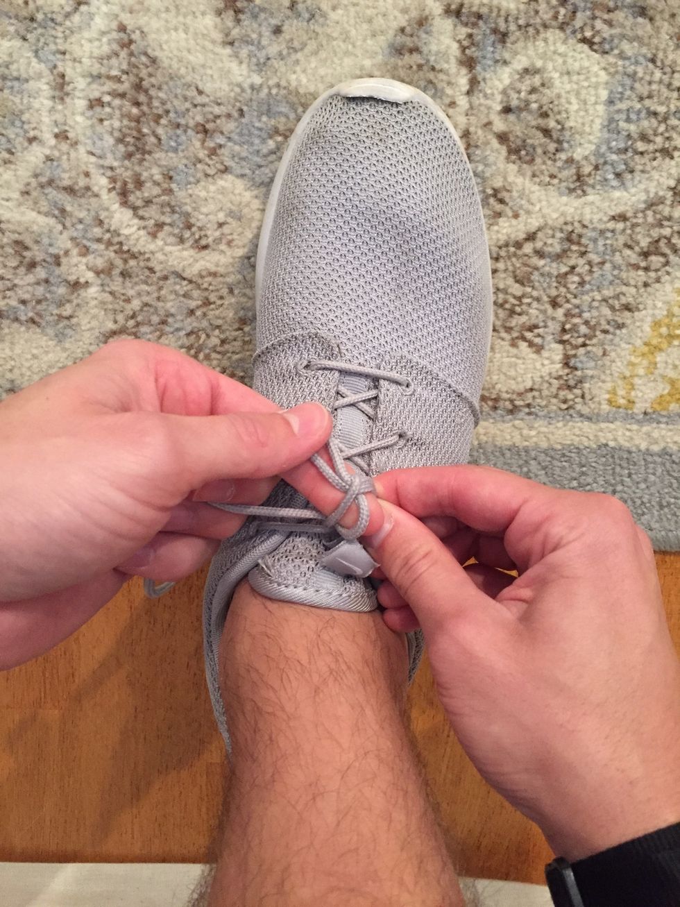 Once over, take the "loop" you just  made and go under the pinched "loop". Still keep the pressure on the pinched "loop" and "crossed over" laces