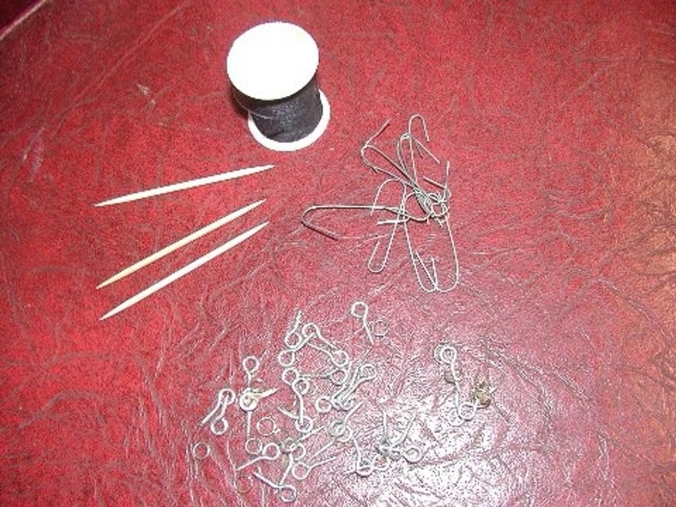 Once painted, you install a small eye hook in the cap and hang it with an ornament hanger and some heavy thread.  I use the toothpicks during the painting process.