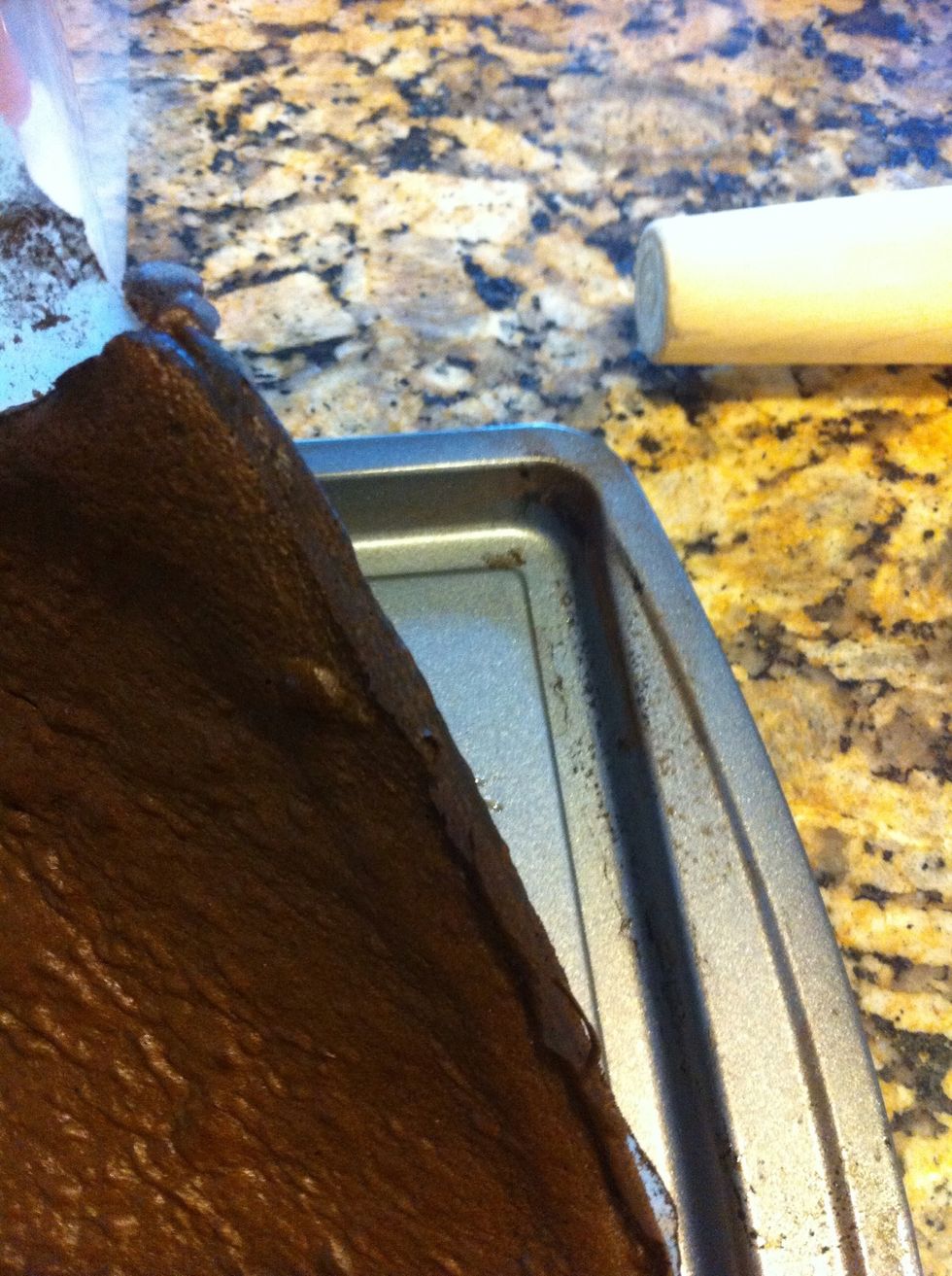 Once ready, pull cake up with a piece of the parchment paper, and lay cake down (parchment paper up) on kitchen towel